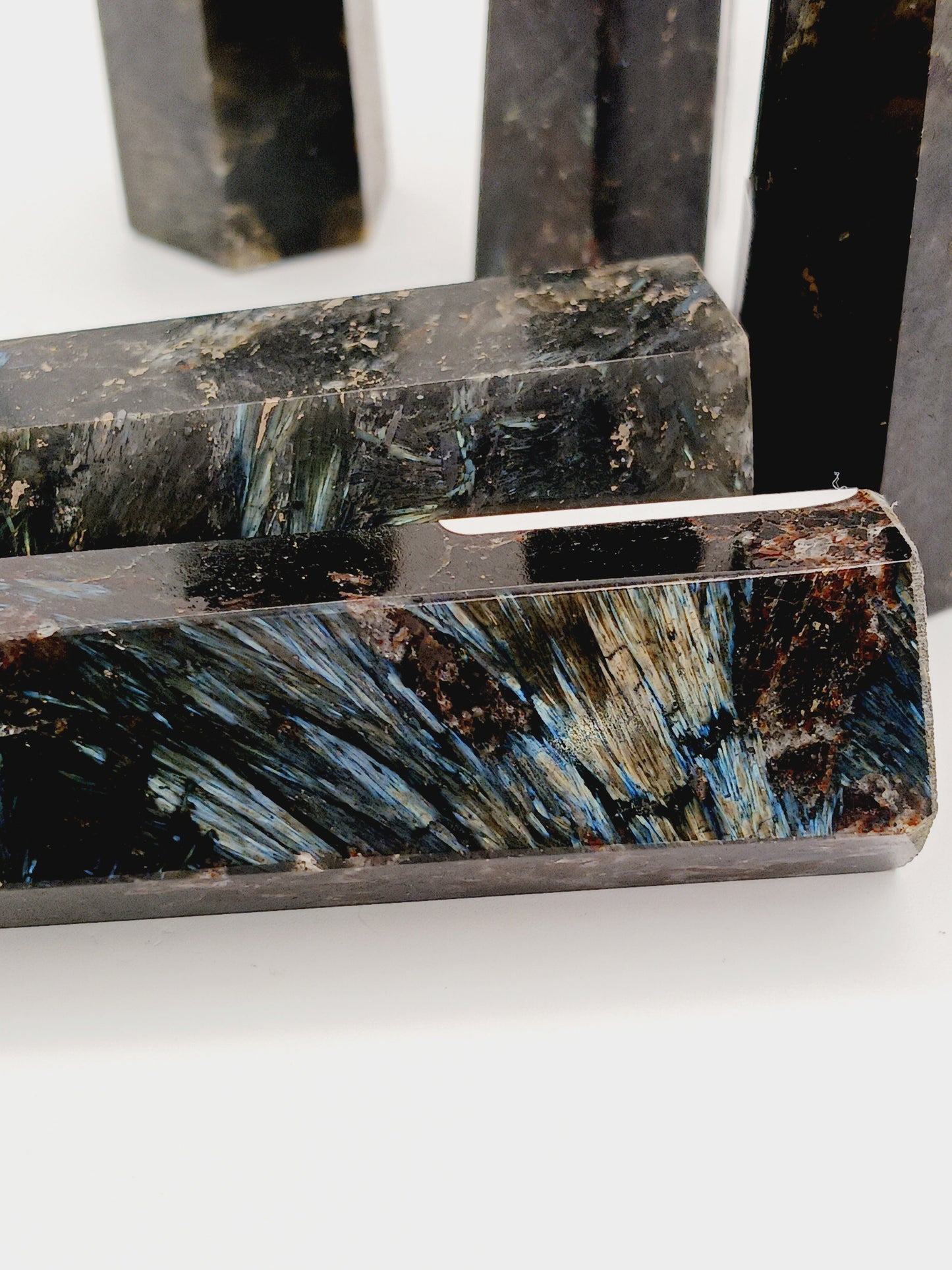 Astrophyllite (firework stone) with garnet tower, 2.5ā3 inches, hand-polished with golden flashes and deep red inclusions, displayed on a white background.