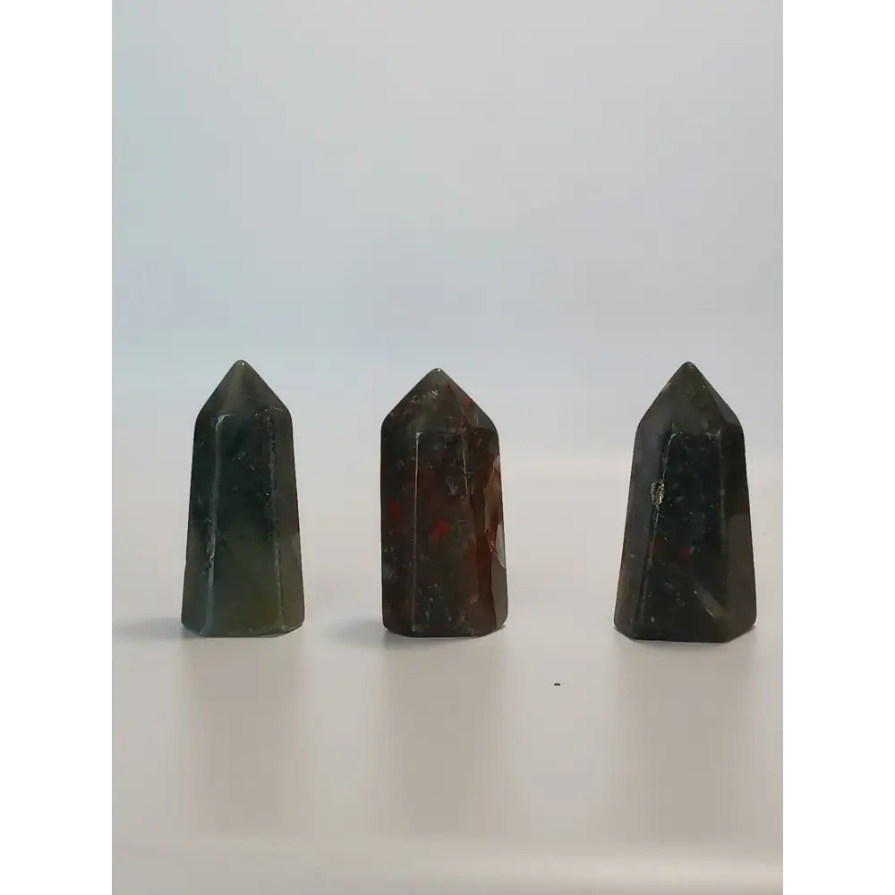 Hand-carved Bloodstone point, 2 to 2.5 inches tall, featuring deep green with natural red flecks, displayed on a white background.