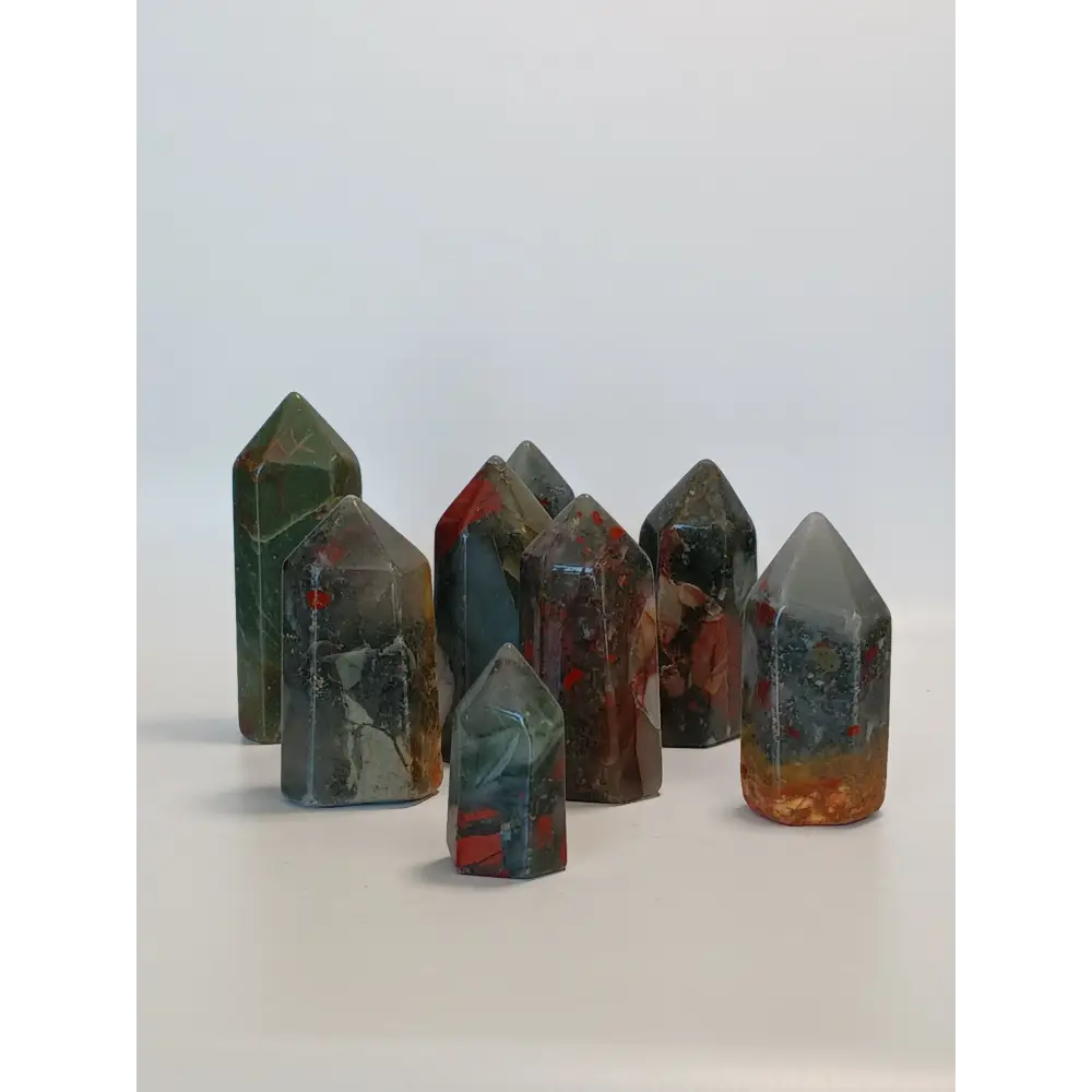Hand-carved Bloodstone point, 2 to 2.5 inches tall, featuring deep green with natural red flecks, displayed on a white background.