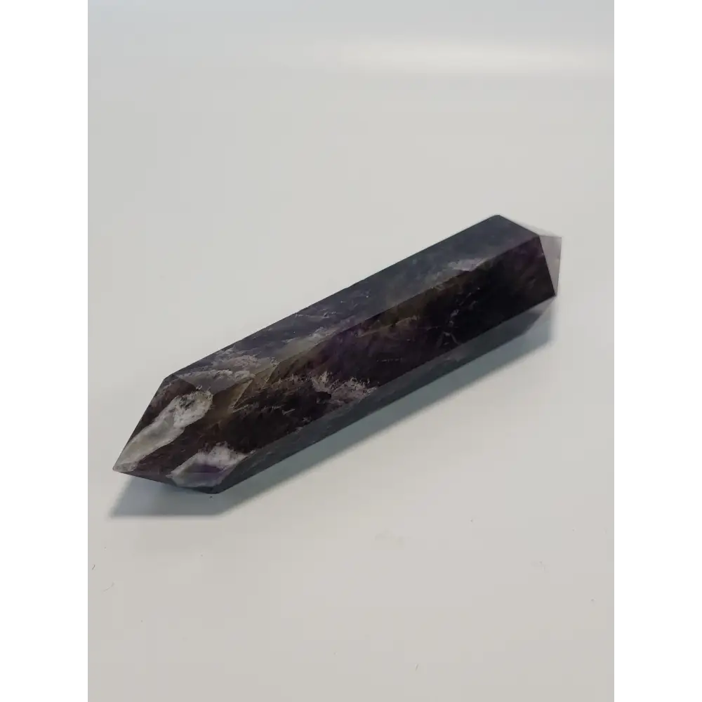 Double terminated Dream Amethyst crystal featuring bold purple and white chevron patterns, displayed on a white background.