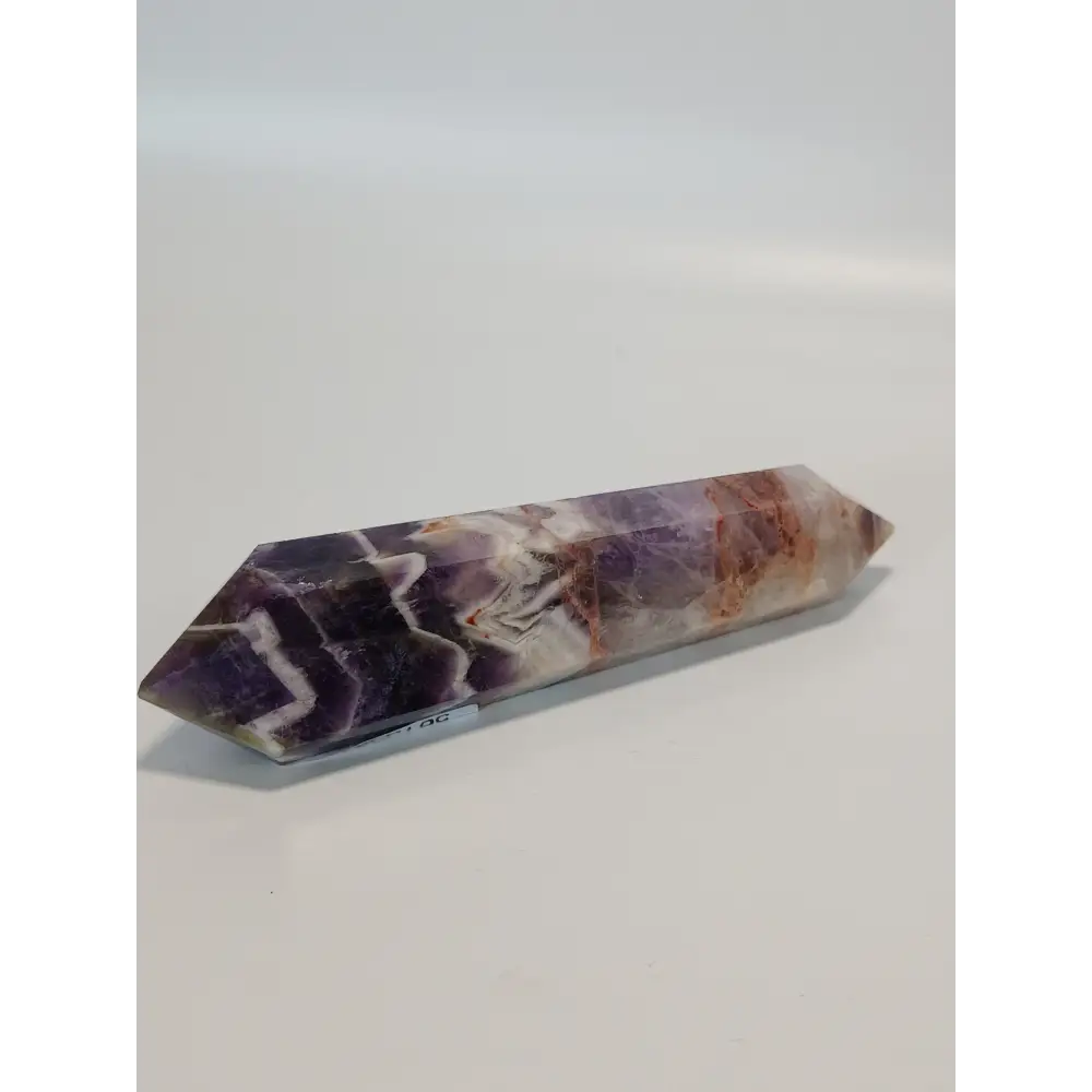 Double terminated Dream Amethyst crystal featuring bold purple and white chevron patterns, displayed on a white background.