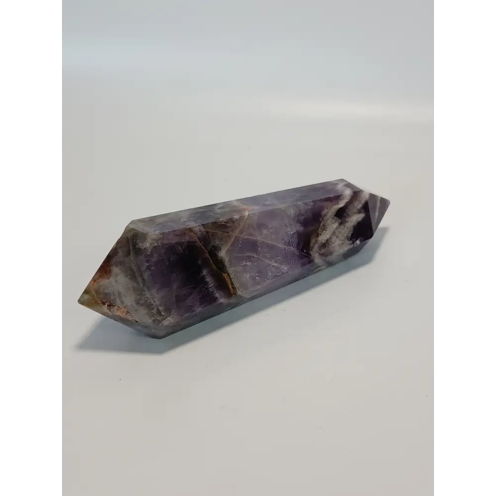 Double terminated Dream Amethyst crystal featuring bold purple and white chevron patterns, displayed on a white background.