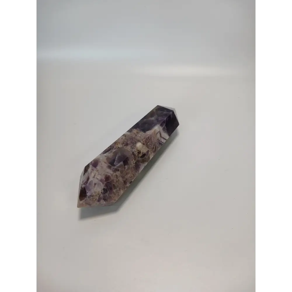 Double terminated Dream Amethyst crystal featuring bold purple and white chevron patterns, displayed on a white background.