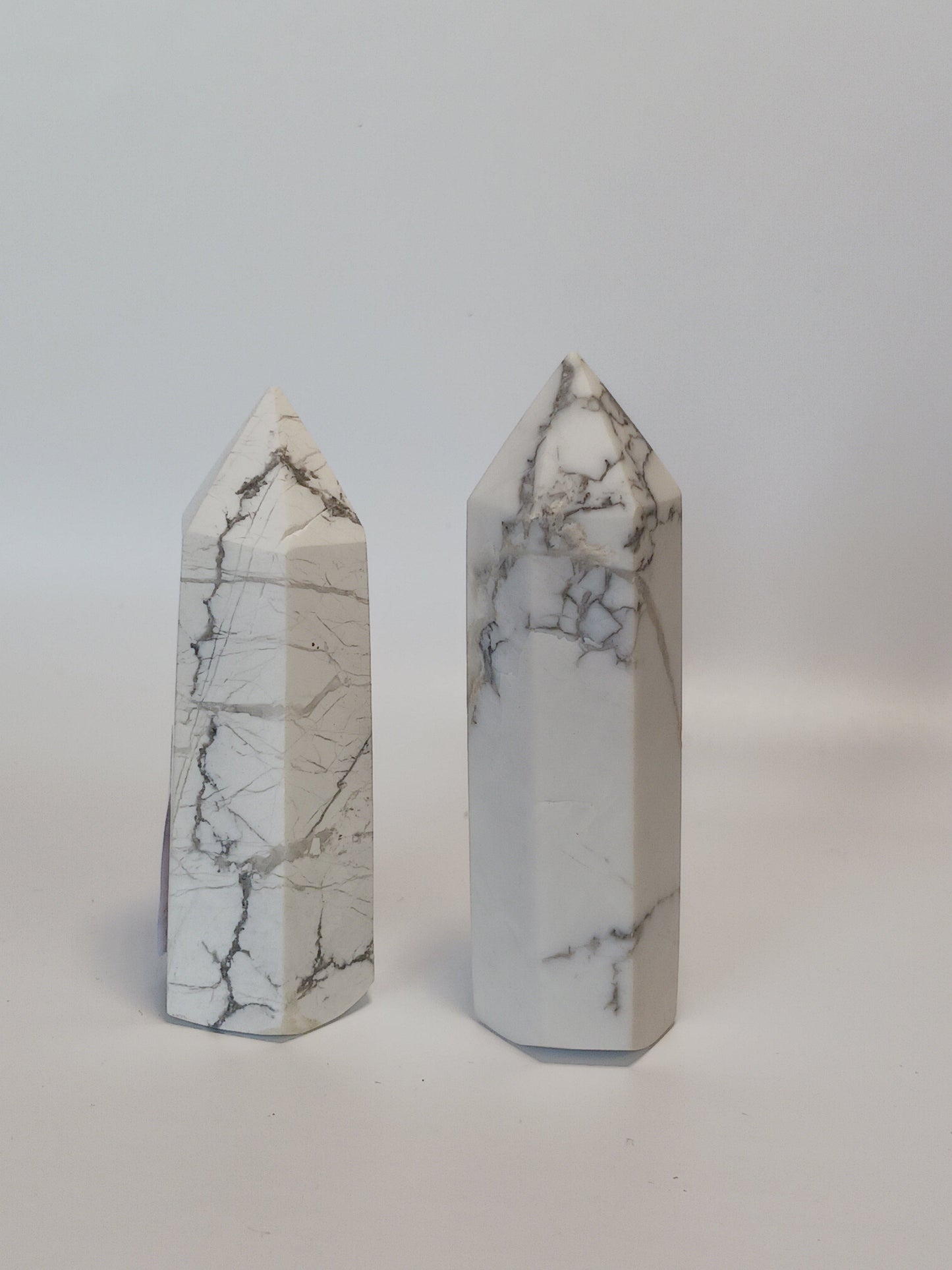 Hand-carved Howlite point featuring soft white coloring with graceful gray veining, displayed on a white background.