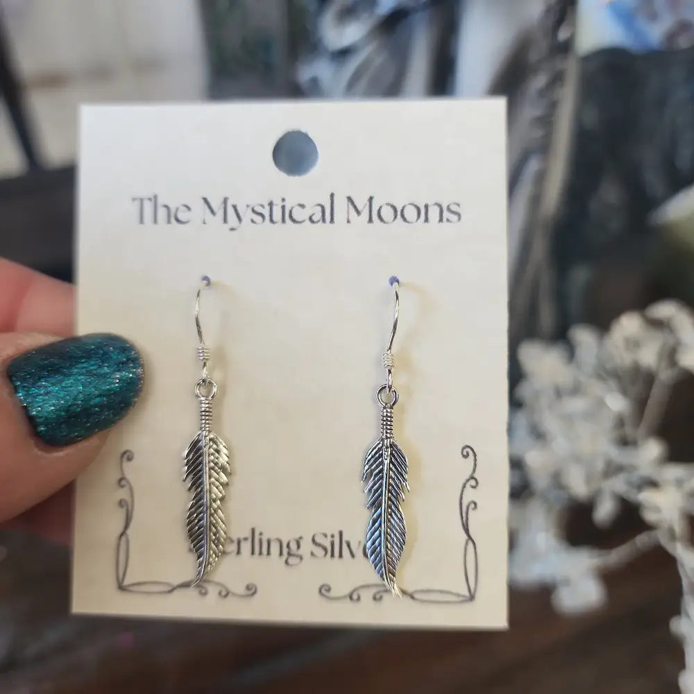 Sterling silver medium feather earrings with delicate detailing, displayed on a white background. Perfect for spiritual freedom, guidance, and everyday magic.