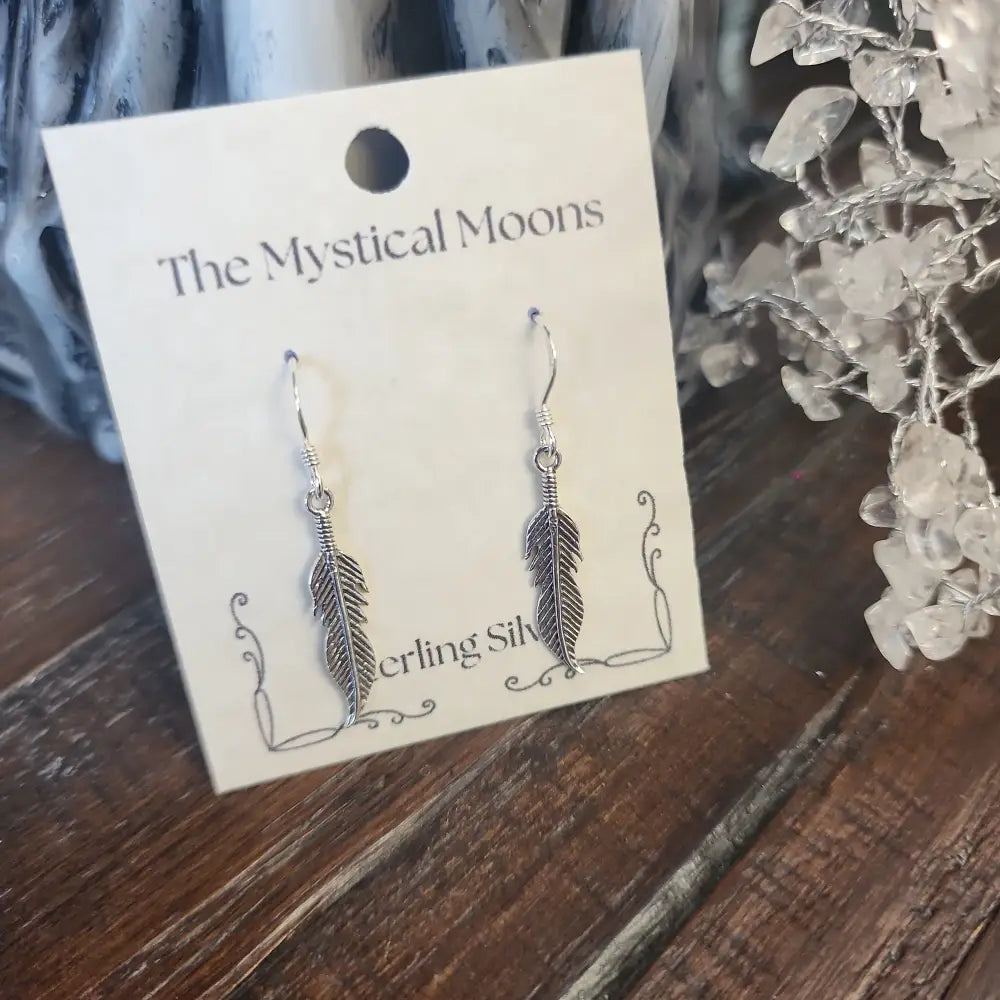 Sterling silver medium feather earrings with delicate detailing, displayed on a white background. Perfect for spiritual freedom, guidance, and everyday magic.
