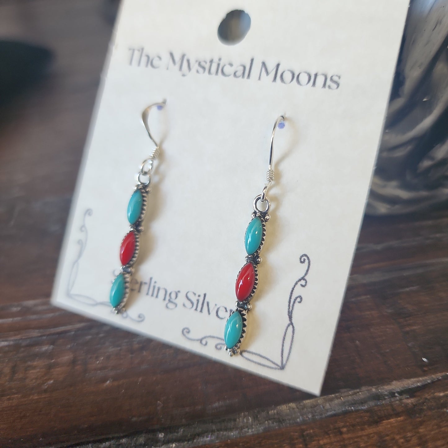 Sterling silver earrings with Southwest-inspired design featuring vibrant turquoise stones, displayed on a white background. Perfect for protection, wisdom, and desert magic.