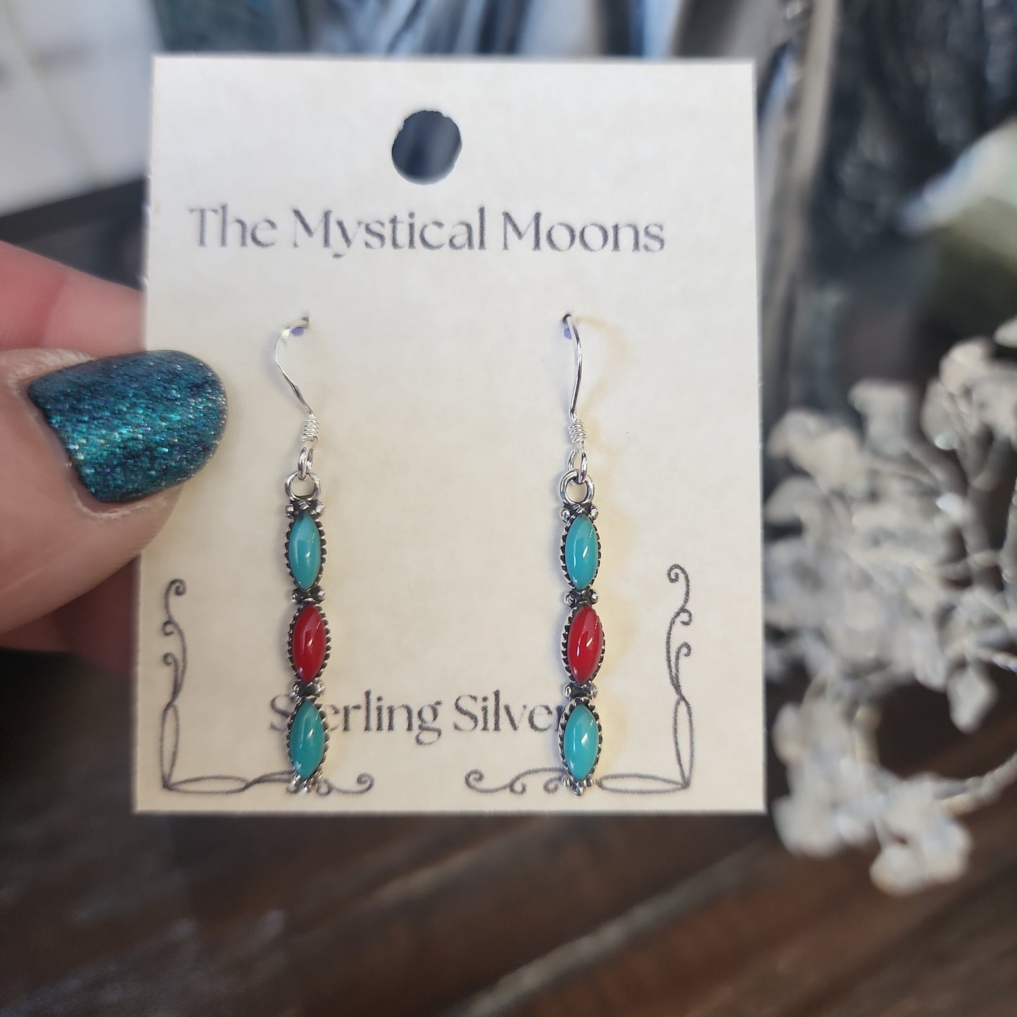 Sterling silver earrings with Southwest-inspired design featuring vibrant turquoise stones, displayed on a white background. Perfect for protection, wisdom, and desert magic.