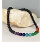 8 mm beaded necklace featuring black lava stones and a row of colorful chakra stones, displayed on a white background. Perfect for grounding, chakra balance, and aromatherapy.
