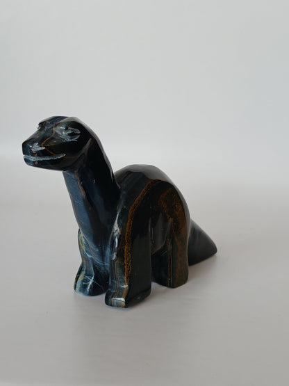 Assorted hand-carved animal figurines made from Blue Tiger’s Eye, Fluorite, and Tiger’s Eye crystals, each featuring unique colors and patterns, displayed on a white background.
