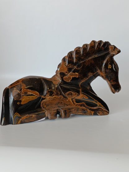 Assorted hand-carved animal figurines made from Blue Tiger’s Eye, Fluorite, and Tiger’s Eye crystals, each featuring unique colors and patterns, displayed on a white background.