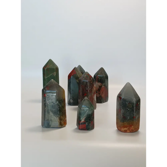 Hand-carved Bloodstone point, 2 to 2.5 inches tall, featuring deep green with natural red flecks, displayed on a white background.

