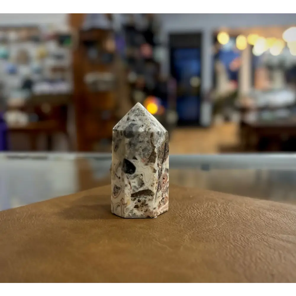 Hand-carved Mexican Crazy Lace Agate tower featuring intricate, colorful swirls and banded patterns, displayed on a white background.