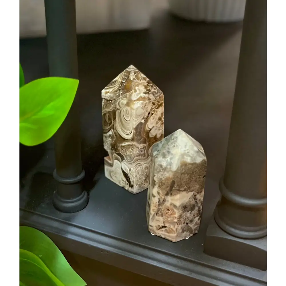 Hand-carved Mexican Crazy Lace Agate tower featuring intricate, colorful swirls and banded patterns, displayed on a white background.