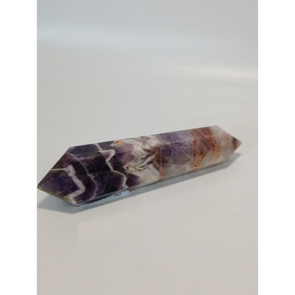 Double terminated Dream Amethyst crystal featuring bold purple and white chevron patterns, displayed on a white background.