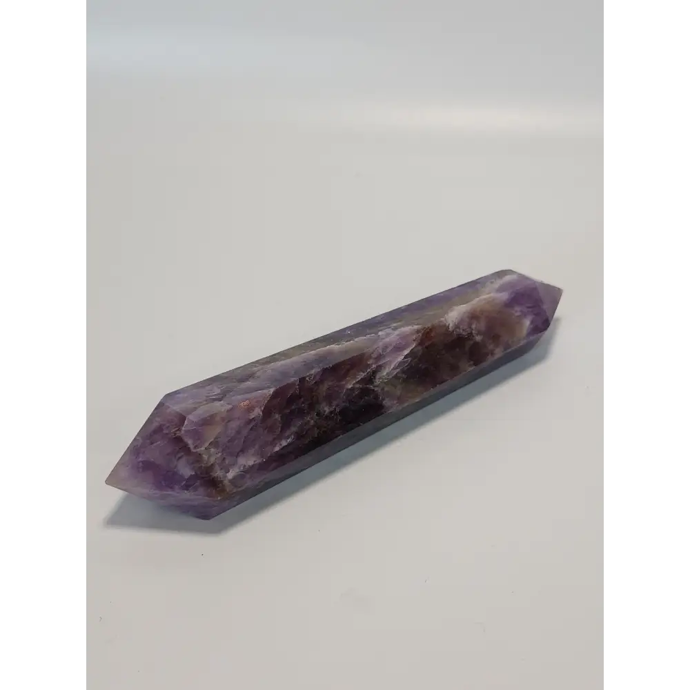 Double terminated Dream Amethyst crystal featuring bold purple and white chevron patterns, displayed on a white background.