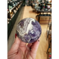 Hand-polished Dream Amethyst sphere featuring vivid purple and white chevron bands, displayed on a white background.