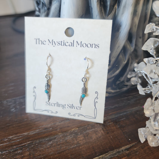 Sterling silver earrings featuring an abstract feather design, displayed on a white background. Perfect for freedom, artistic expression, and modern magic.
