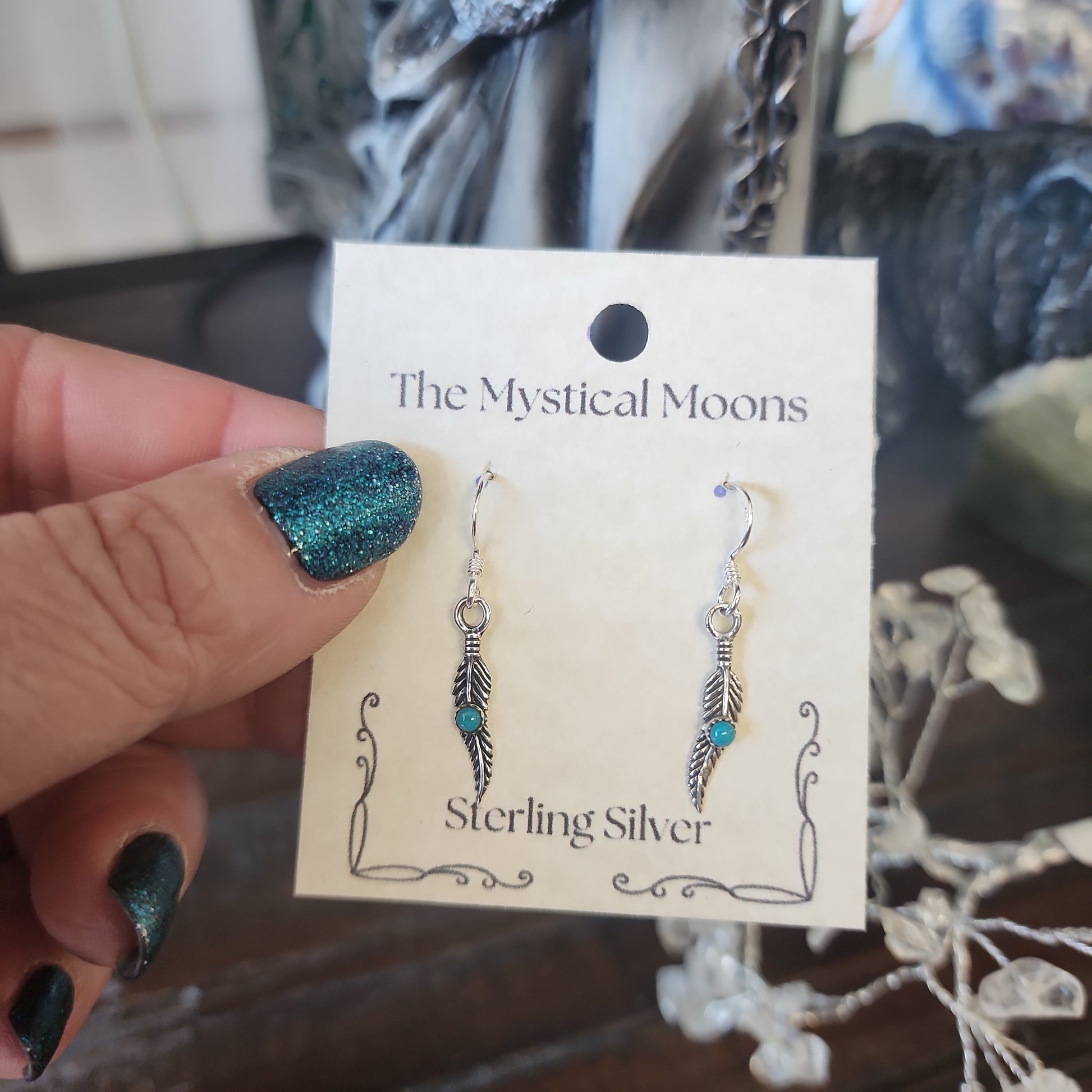 Sterling silver earrings featuring an abstract feather design, displayed on a white background. Perfect for freedom, artistic expression, and modern magic.