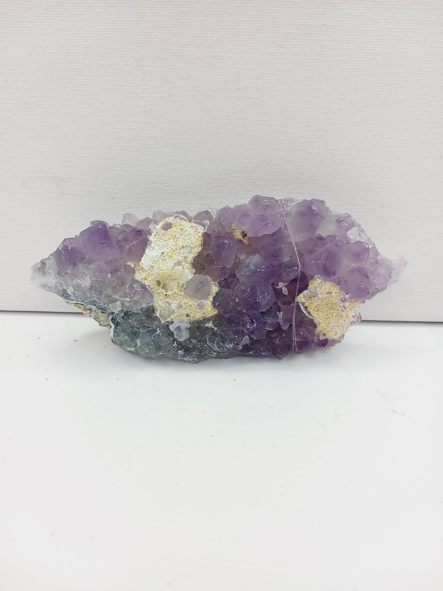 Fine glittery amethyst specimen, featuring sparkling purple points and a shimmering surface, displayed on a white background.
