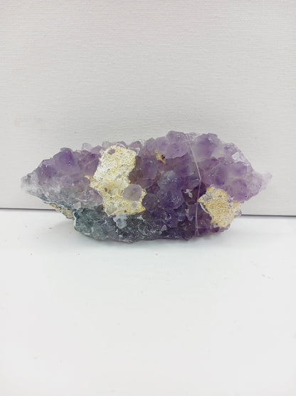 Fine glittery amethyst specimen, featuring sparkling purple points and a shimmering surface, displayed on a white background.