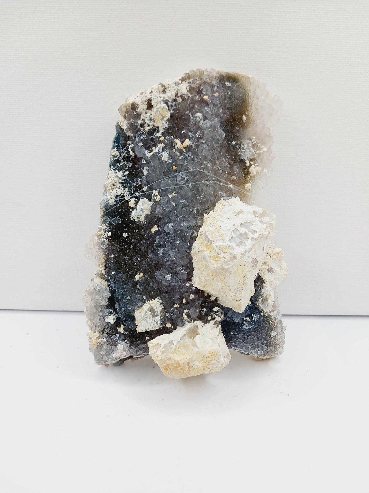 Fine glittery amethyst specimen, featuring sparkling purple points and a shimmering surface, displayed on a white background.