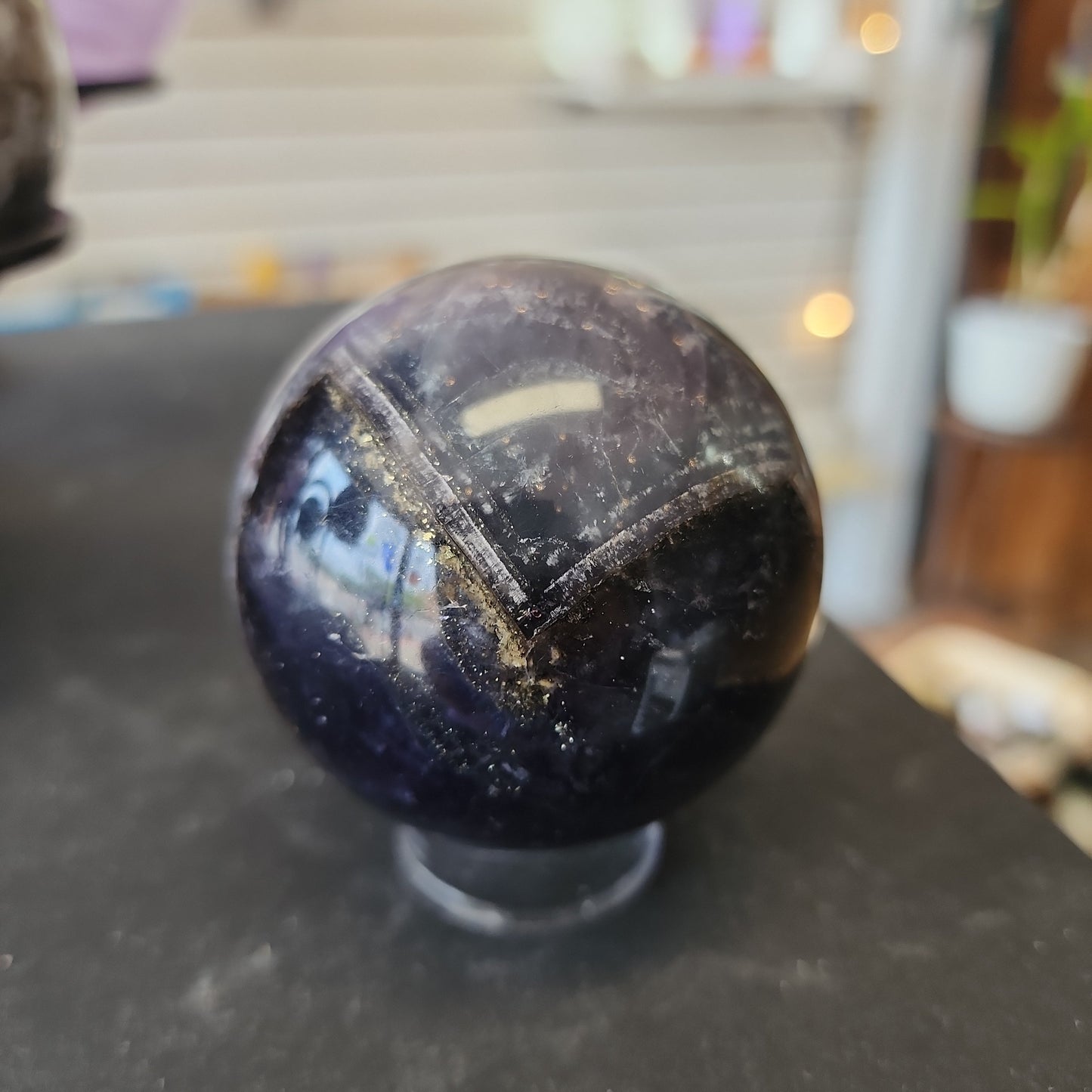 Hand-polished Fluorite with Pyrite sphere featuring vibrant green, purple, or blue fluorite hues with sparkling pyrite inclusions, displayed on a white background.