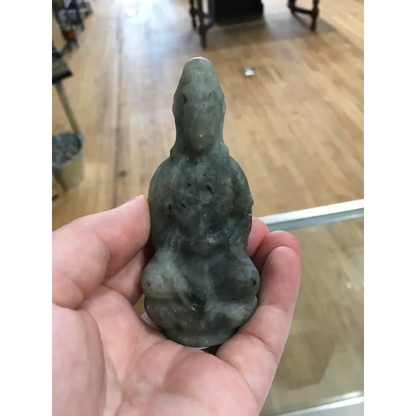 Hand-carved Goddess Guanyin statue made from genuine labradorite, featuring iridescent flashes of blue, green, and gold, displayed upright on a white background.