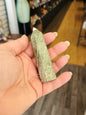 Hand-carved Green Zebra Jasper tower featuring bold green and white banded patterns, displayed on a white background.