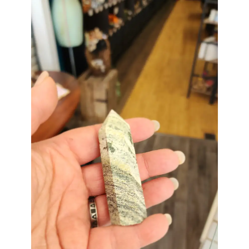Hand-carved Green Zebra Jasper tower featuring bold green and white banded patterns, displayed on a white background.