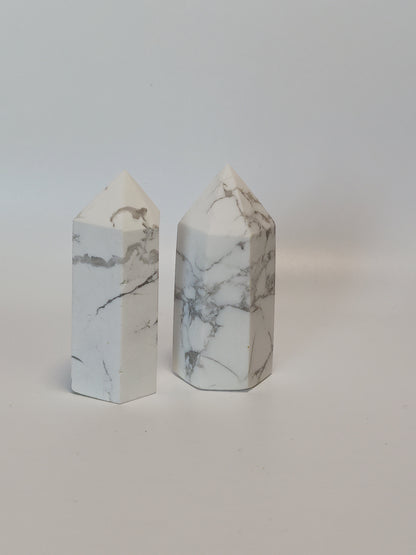 Hand-carved Howlite point featuring soft white coloring with graceful gray veining, displayed on a white background.