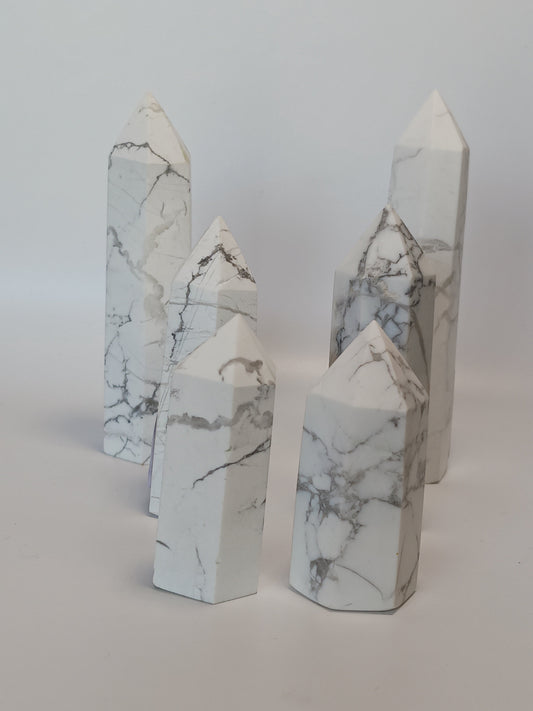 Hand-carved Howlite point featuring soft white coloring with graceful gray veining, displayed on a white background.