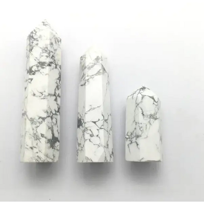 Hand-carved Howlite point featuring soft white coloring with graceful gray veining, displayed on a white background.