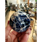 Hand-polished Sodalite sphere featuring deep blue hues with natural white marbling, displayed on a white background.