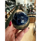 Hand-polished Sodalite sphere featuring deep blue hues with natural white marbling, displayed on a white background.