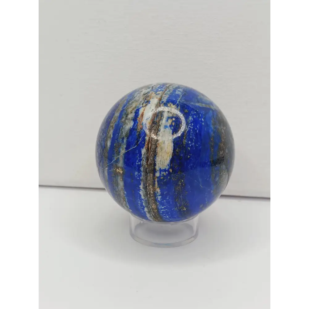 Marble-like sphere with blue and white patterns on a white background