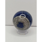 Close-up of a blue and gray stone with a white circle on a light gray background
