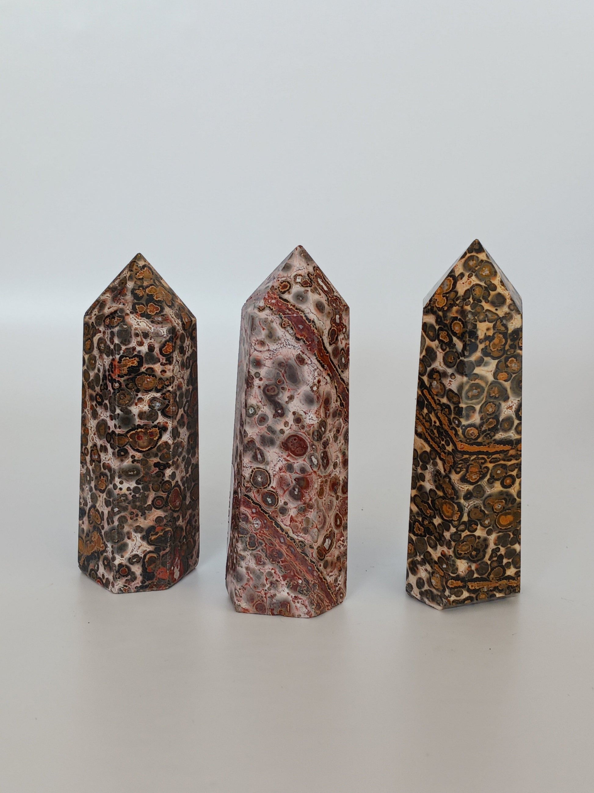 Hand-carved Leopard Jasper point featuring bold, earthy spotted patterns and a polished finish, displayed on a white background.