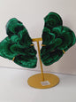 Pair of polished malachite slabs with vibrant green banding, displayed upright on a metal stand against a white background.