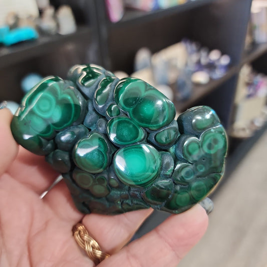 Hand-selected malachite specimen with vibrant green bands and natural patterns, displayed on a white background. Perfect for transformation, protection, and heart chakra healing.