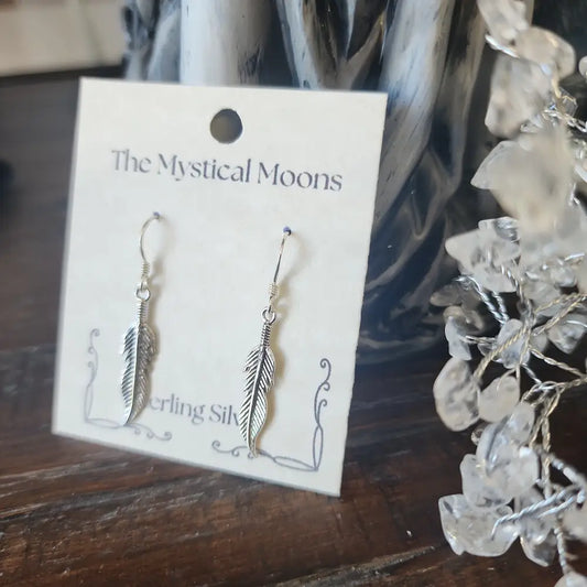 Sterling silver medium feather earrings with delicate detailing, displayed on a white background. Perfect for spiritual freedom, guidance, and everyday magic.