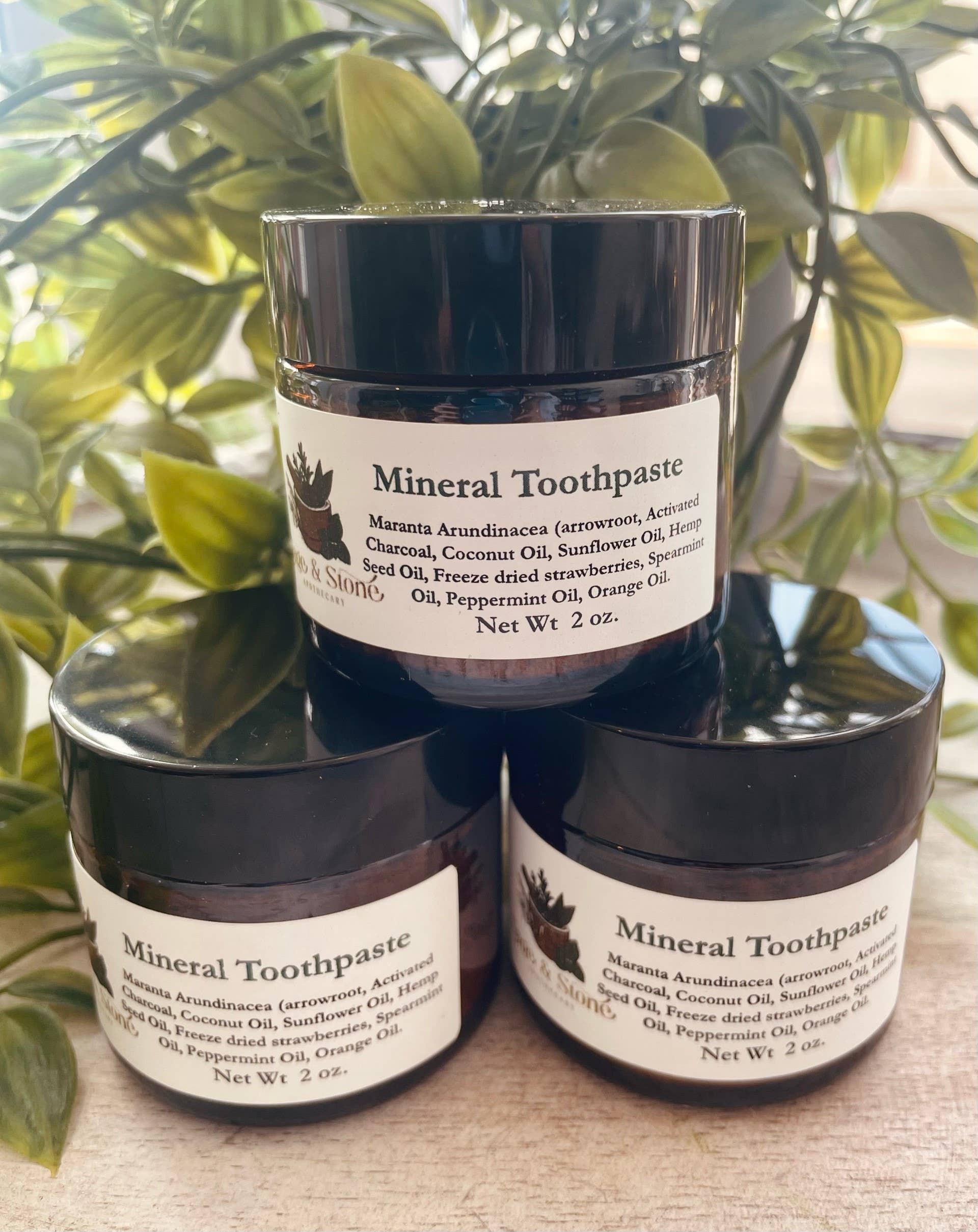 Mineral Toothpaste powder in a small jar, with a bamboo toothbrush beside it, displayed on a white background. Perfect for gently polishing and whitening teeth with natural minerals.