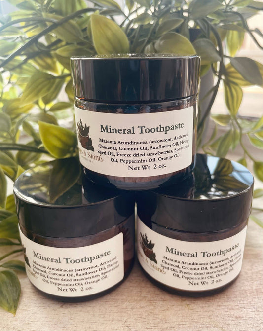 Mineral Toothpaste powder in a small jar, with a bamboo toothbrush beside it, displayed on a white background. Perfect for gently polishing and whitening teeth with natural minerals.