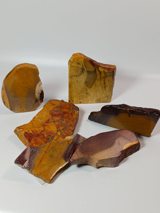 Hand-polished Mookaite slab, 2–2.5 inches, with vibrant red, yellow, and cream patterns, displayed on a white background.