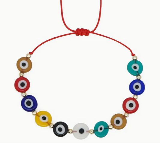 Necklace with colorful evil eye beads on a red cord against a white background