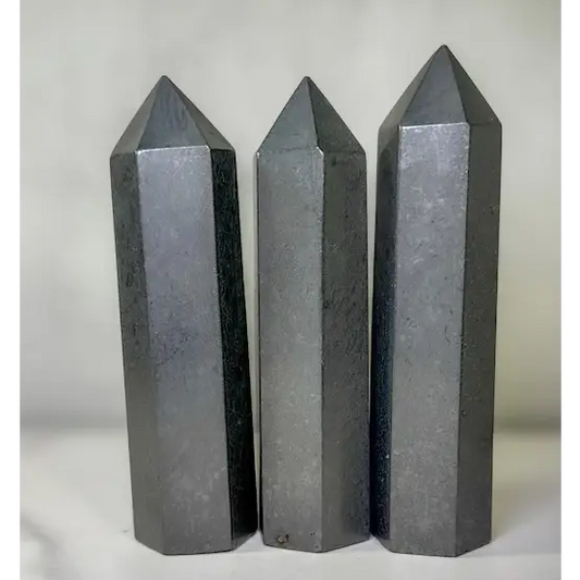 Hand-carved Noble Shungite tower featuring a lustrous, jet-black finish, displayed on a white background.