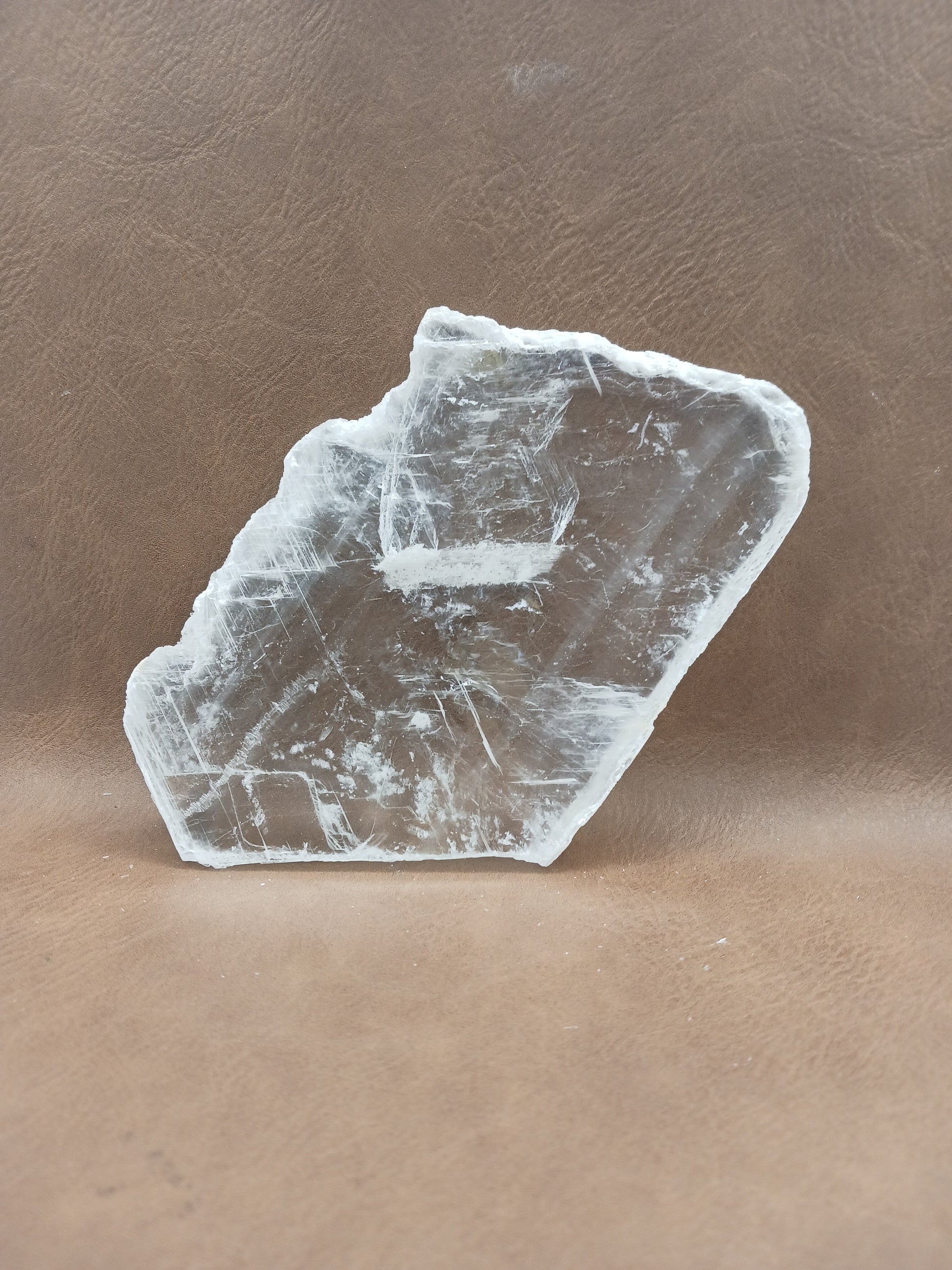 Pink selenite slab, polished with soft rosy hues, displayed on a white background.