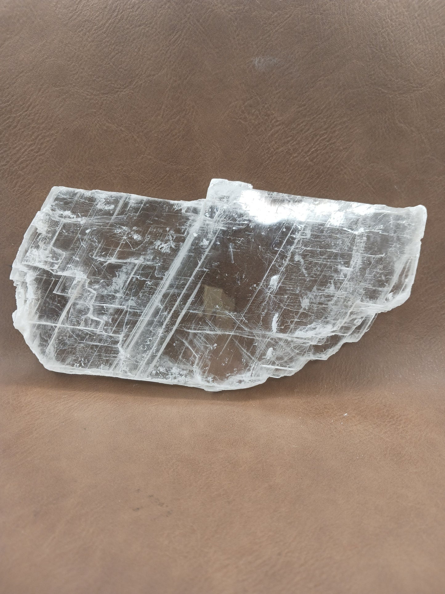 Pink selenite slab, polished with soft rosy hues, displayed on a white background.