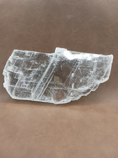Pink selenite slab, polished with soft rosy hues, displayed on a white background.
