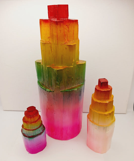 Rainbow selenite tiered tower, polished with a vibrant rainbow sheen and step-like design, displayed on a white background.